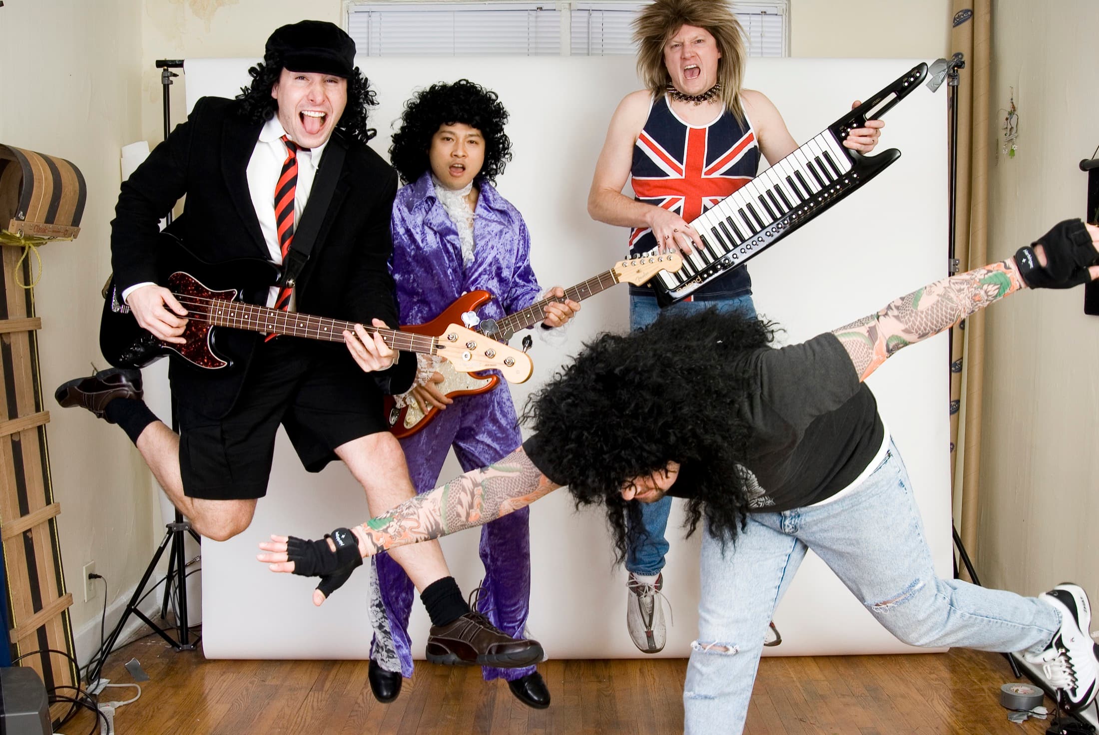 Bueller posing in playful 80s costumes with guitars and a keytar